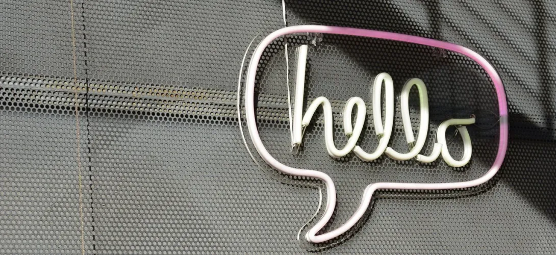 neon sign of the hand-written word hello within a chat bubble